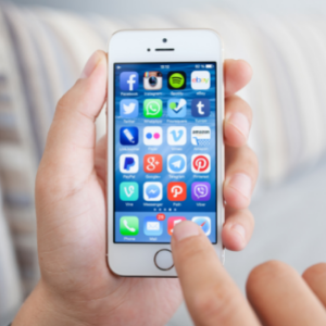 Man holding iPhone 5s with social media network program